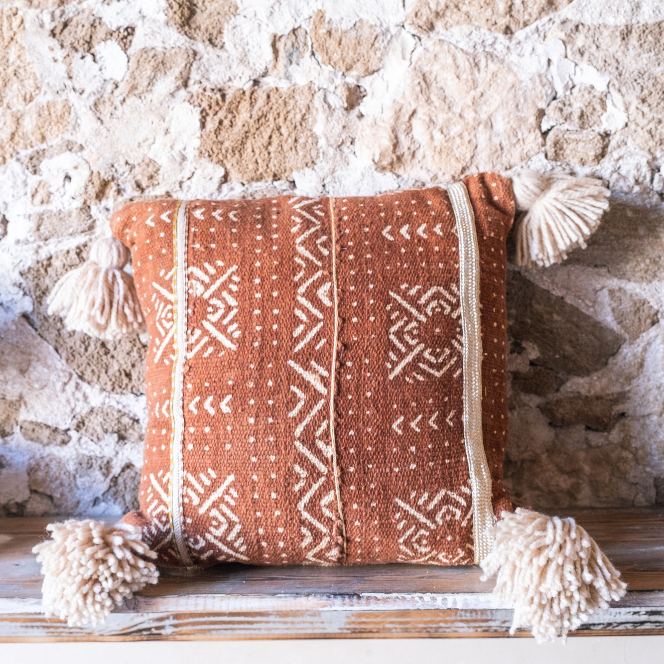 Housse de coussin en textile africain avec pompons faits main